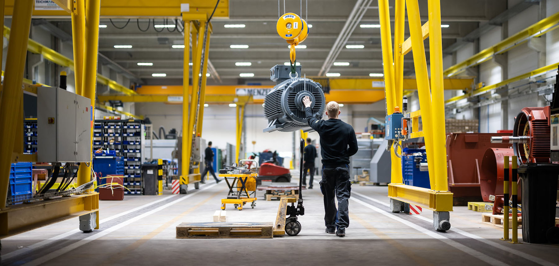 Crane transport through production Crane transport of an electric motor through production